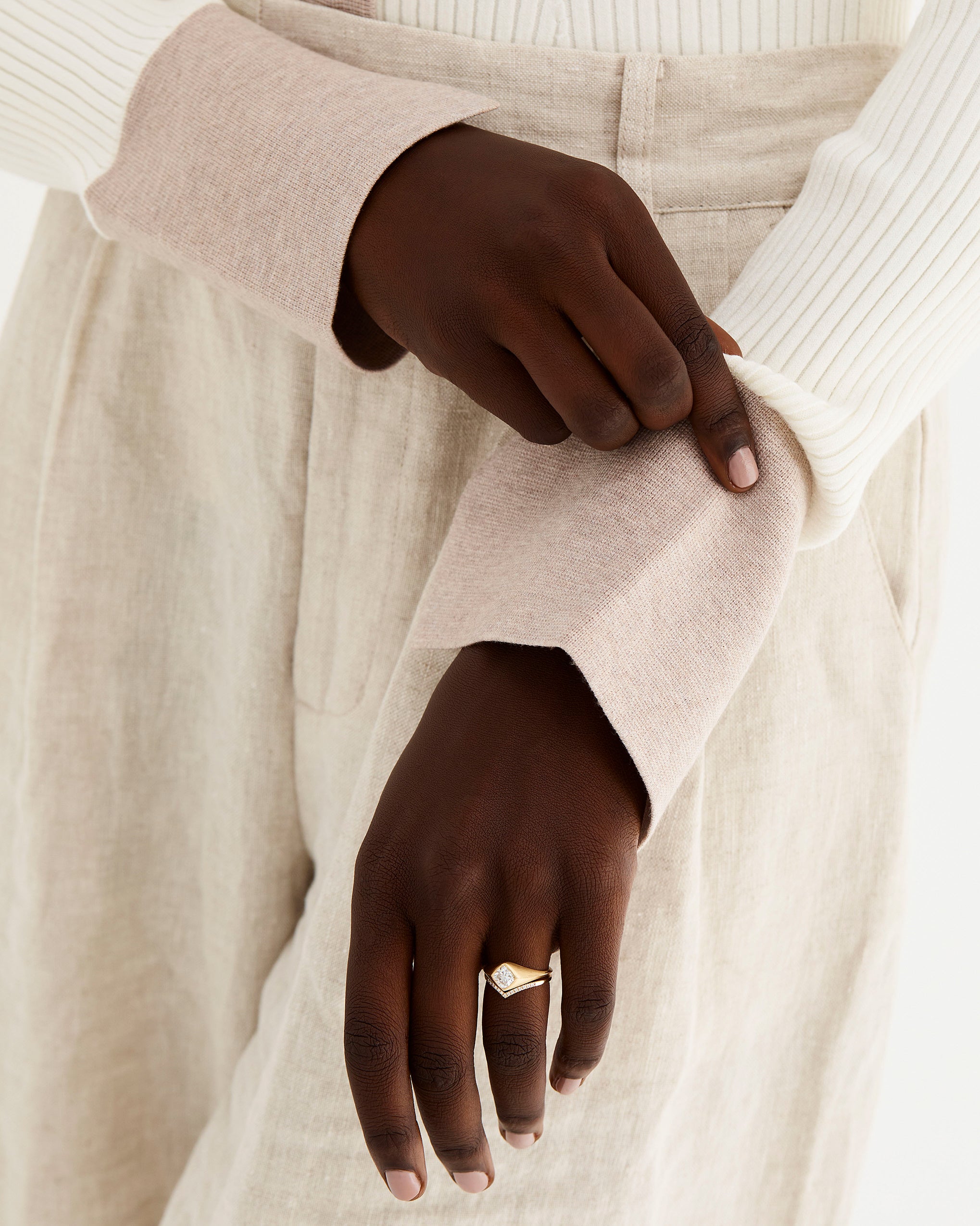 Model wears a signet inspired engagement ring with our gentle point diamond ring. 