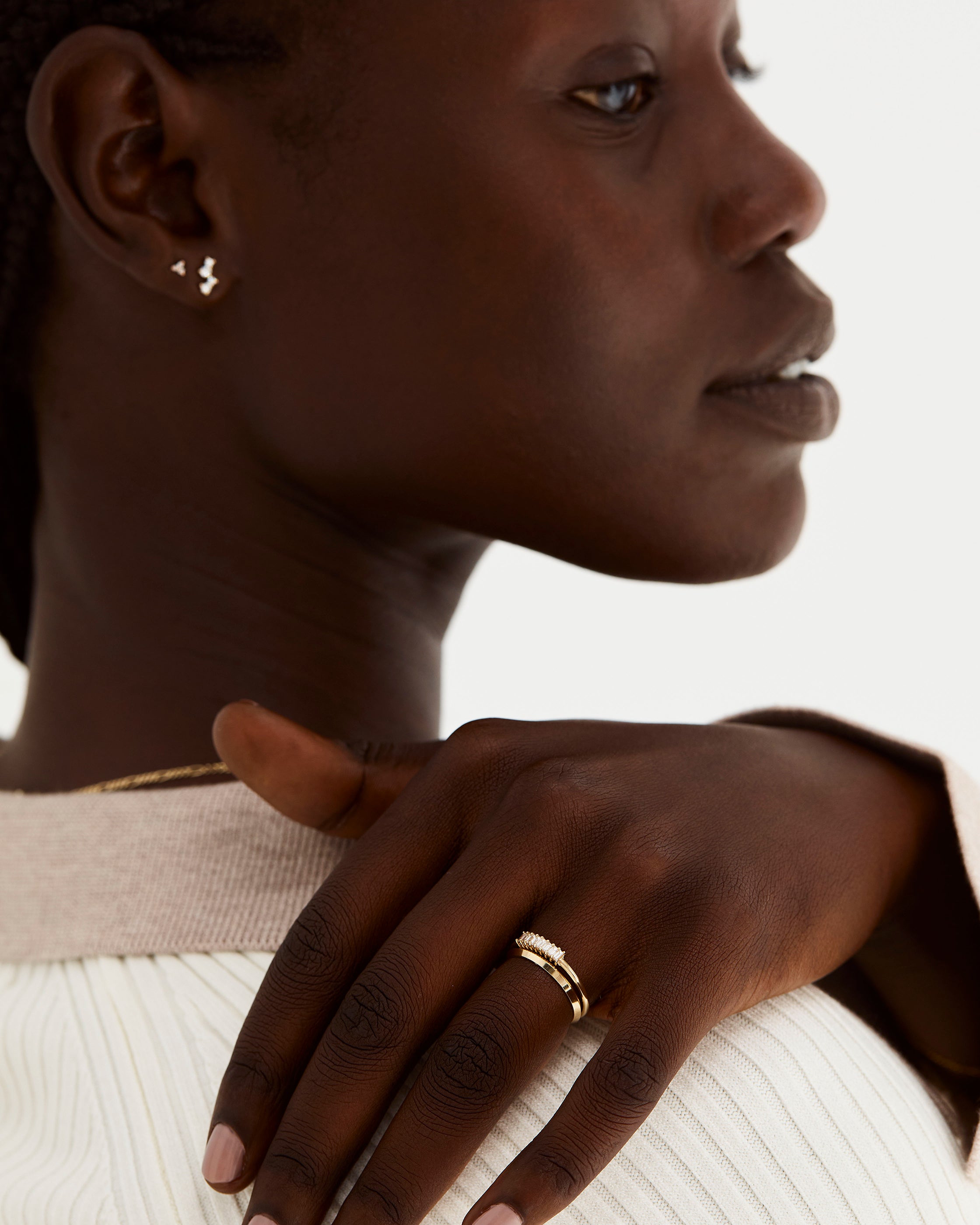 A model wears our diamond baguette cut wrap ring with a knife edge style gold wedding ring. 