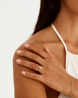 A model wears an oval solitaire style engagement ring with a morganite