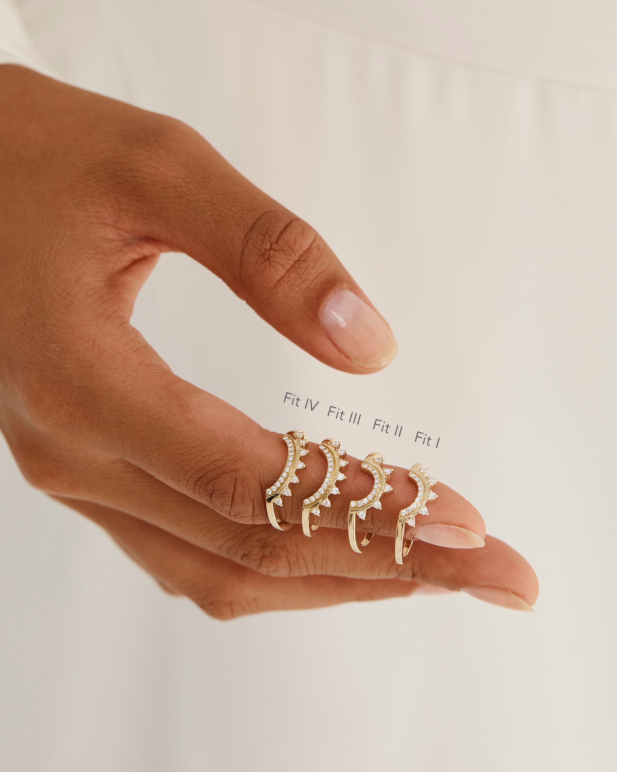 A model shows the four different sizes of a detailed diamond crown style ring