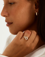 A model wears a diamond crown ring stacked with a trio style engagement ring