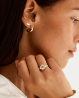 A model wears a diamond crown ring stacked with a trio style engagement ring