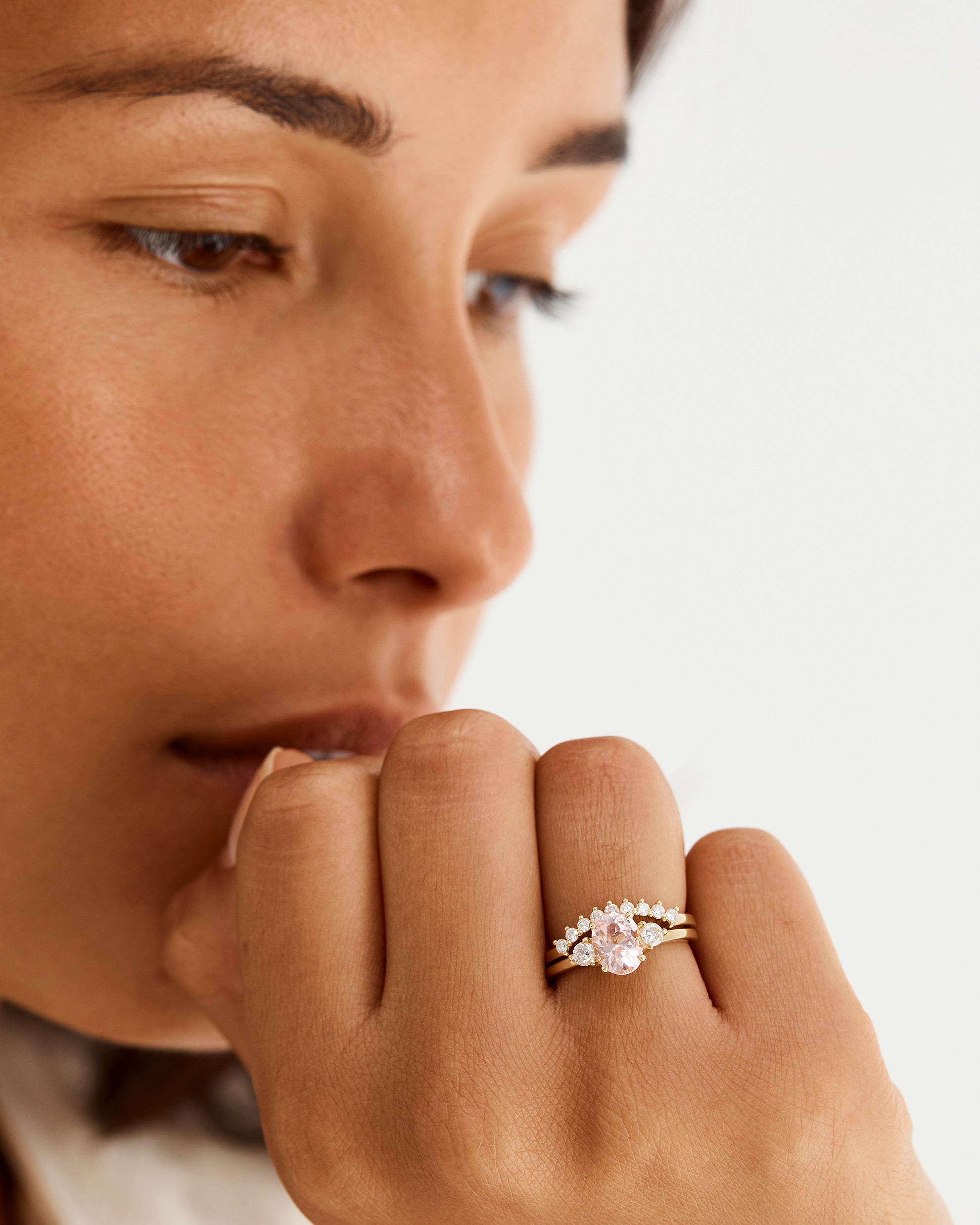A model wears a diamond crown ring stacked with a trio style engagement ring