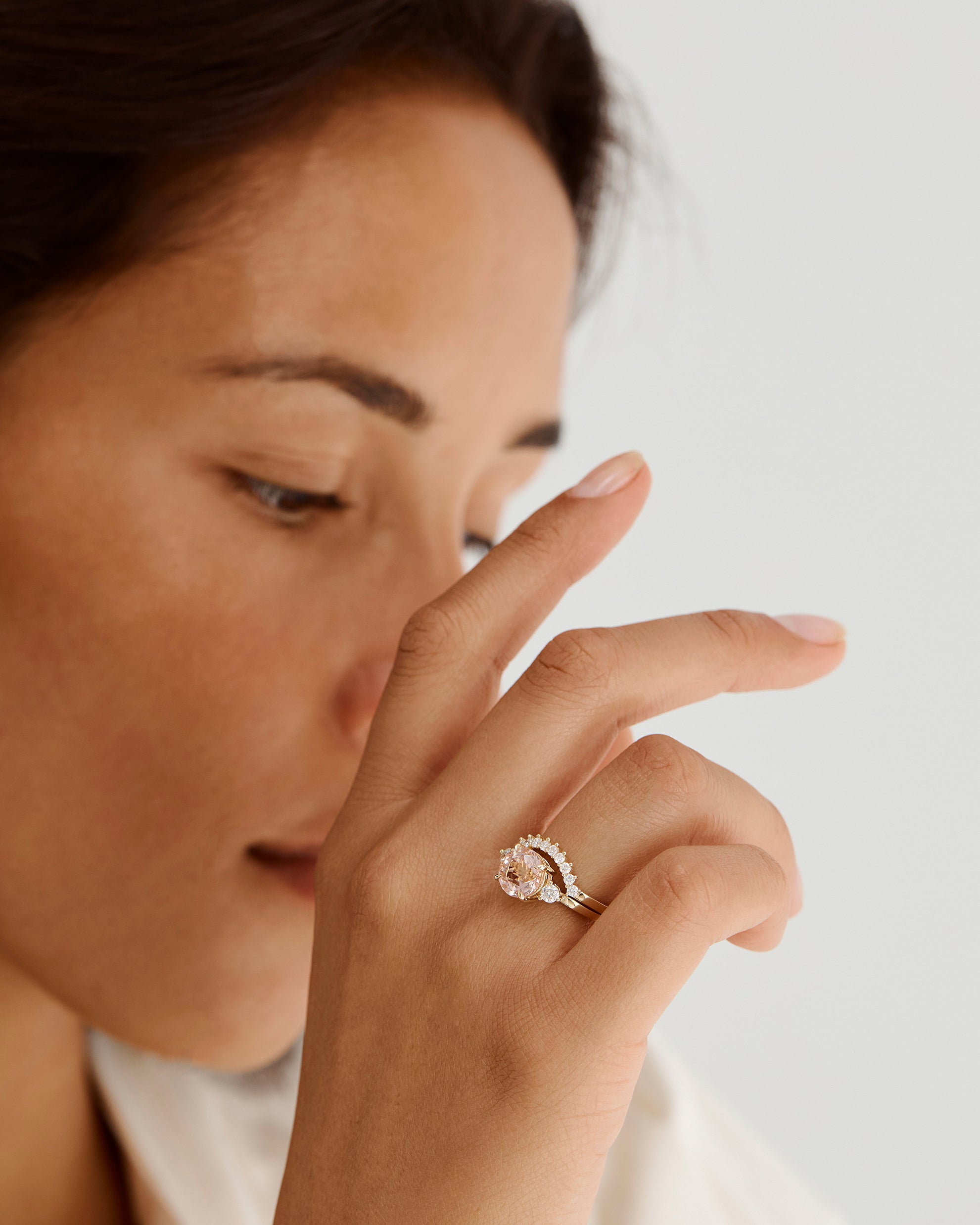 A model wears a diamond crown ring stacked with a trio style engagement ring