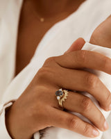 A model wears a diamond dot detailed crown ring stacked with a trio style engagement ring