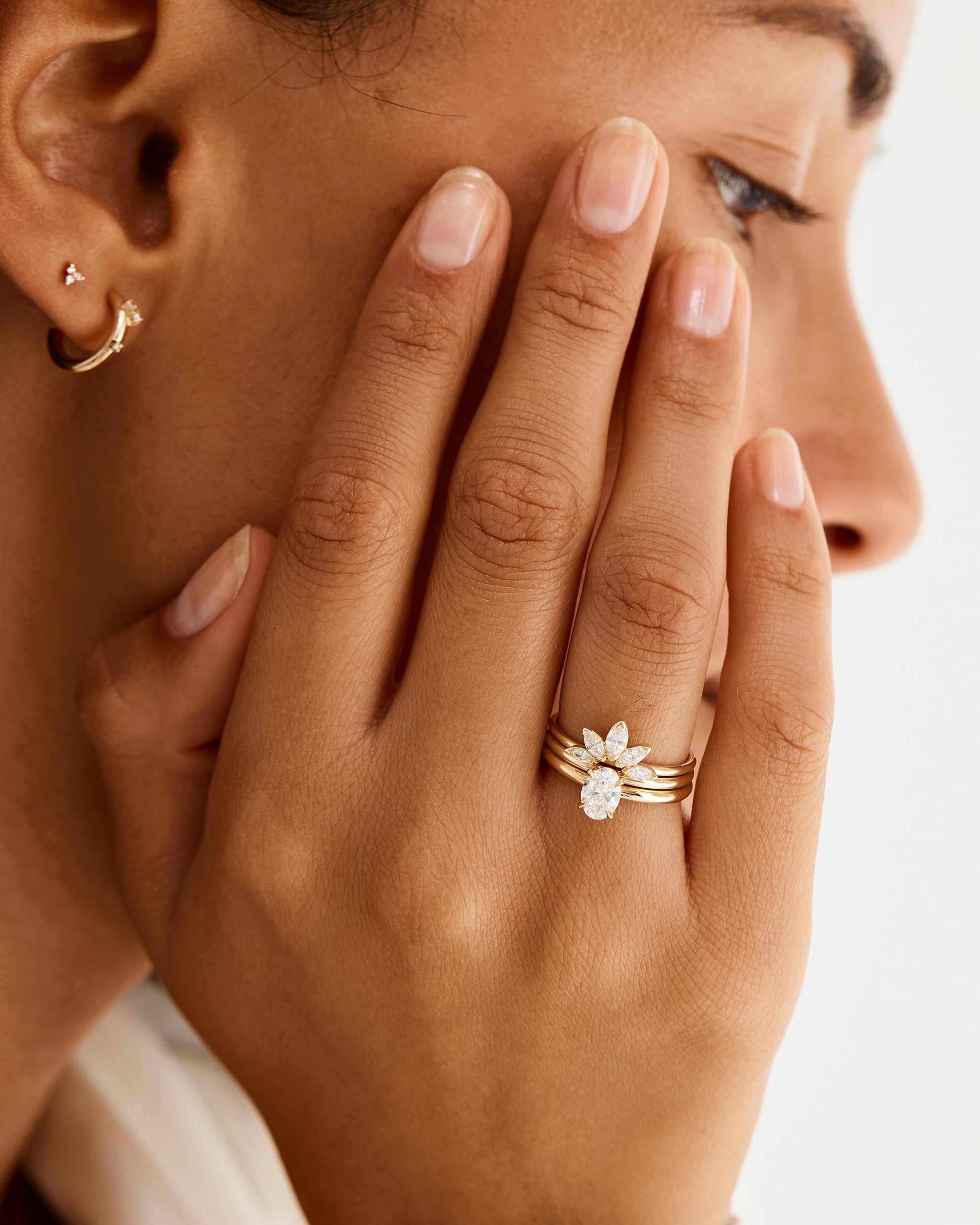 Model wearing the Sun Ring with diamonds, stacked with a solitaire engagement ring 