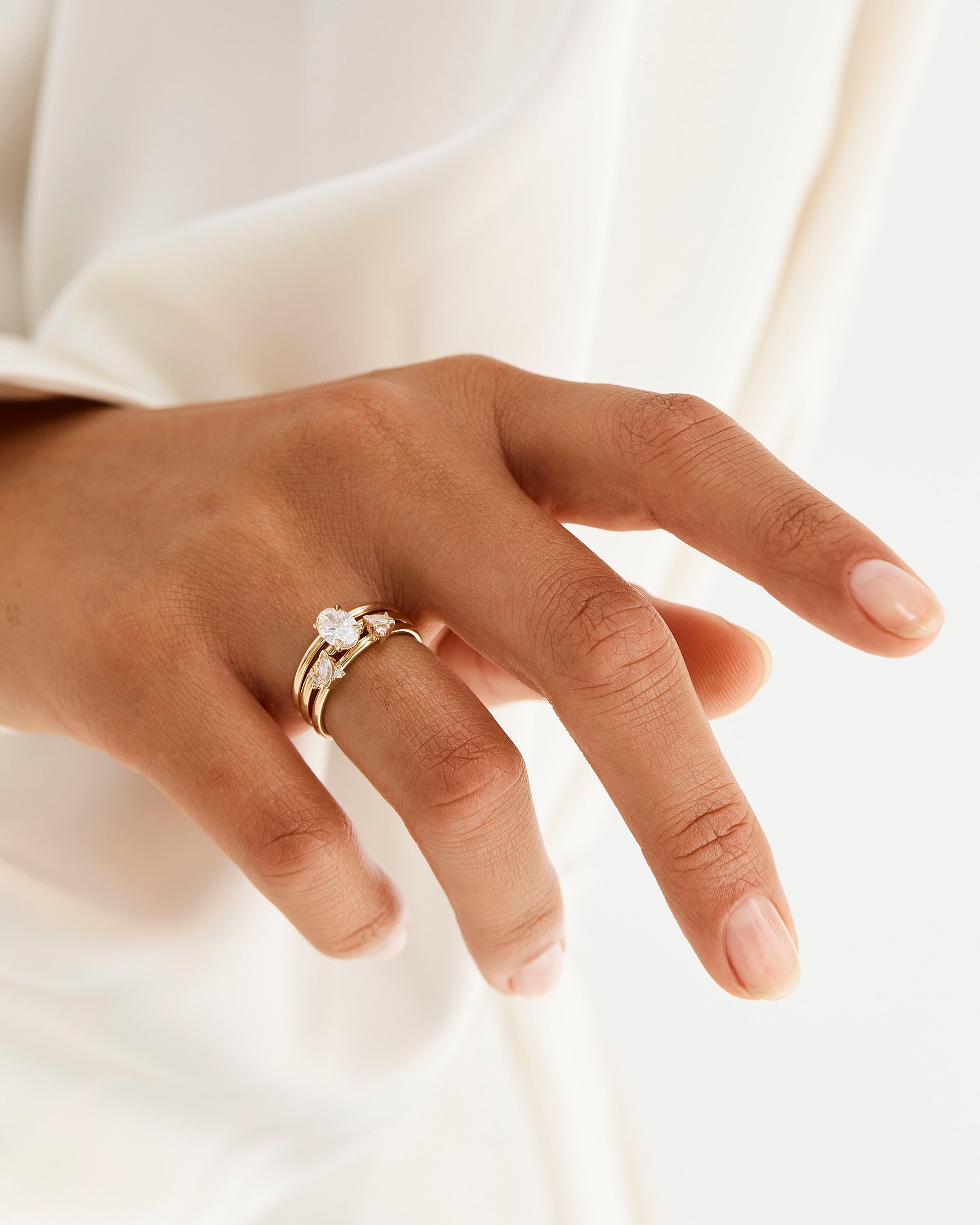 Model wears a diamond cluster ring with a classic diamond signature solitaire 