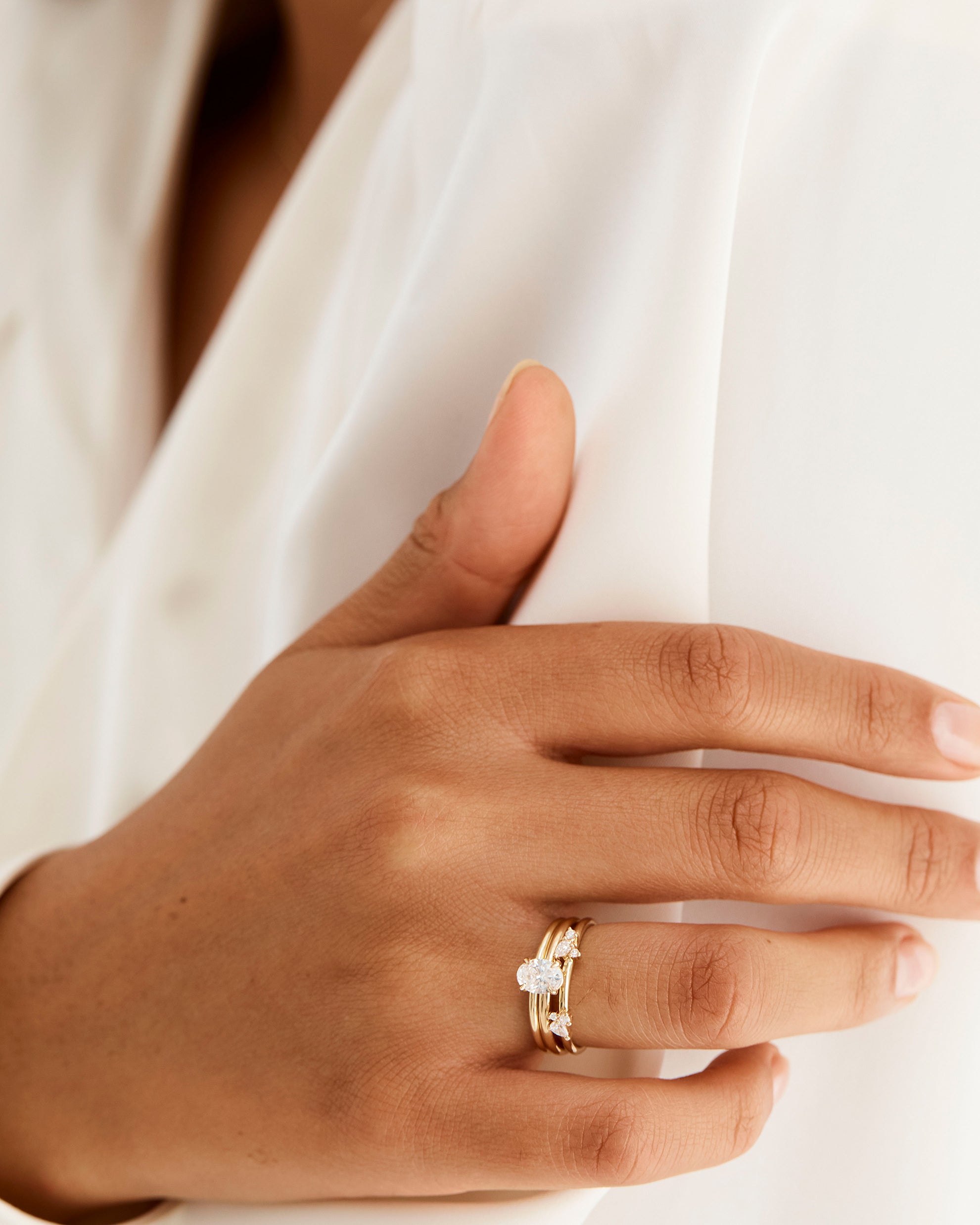 Model wears a diamond cluster ring with a classic diamond signature solitaire