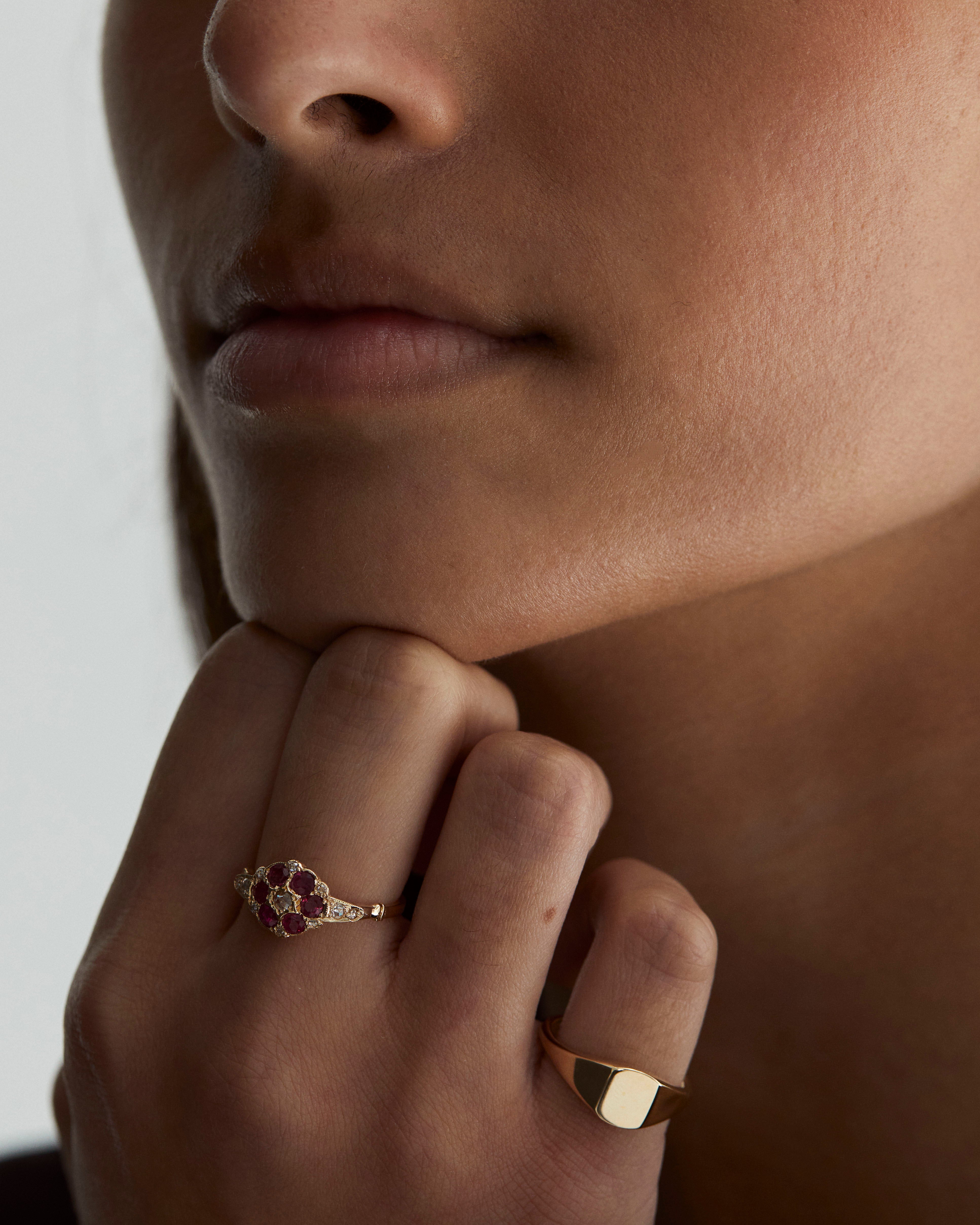 A woman wearing the Polly Vintage Ring | Ruby & Diamonds and the Fei Signet in yellow gold.