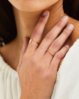 A woman wearing the Organic Stacking ring and Willow Ring | Birthstone, both in yellow gold.
