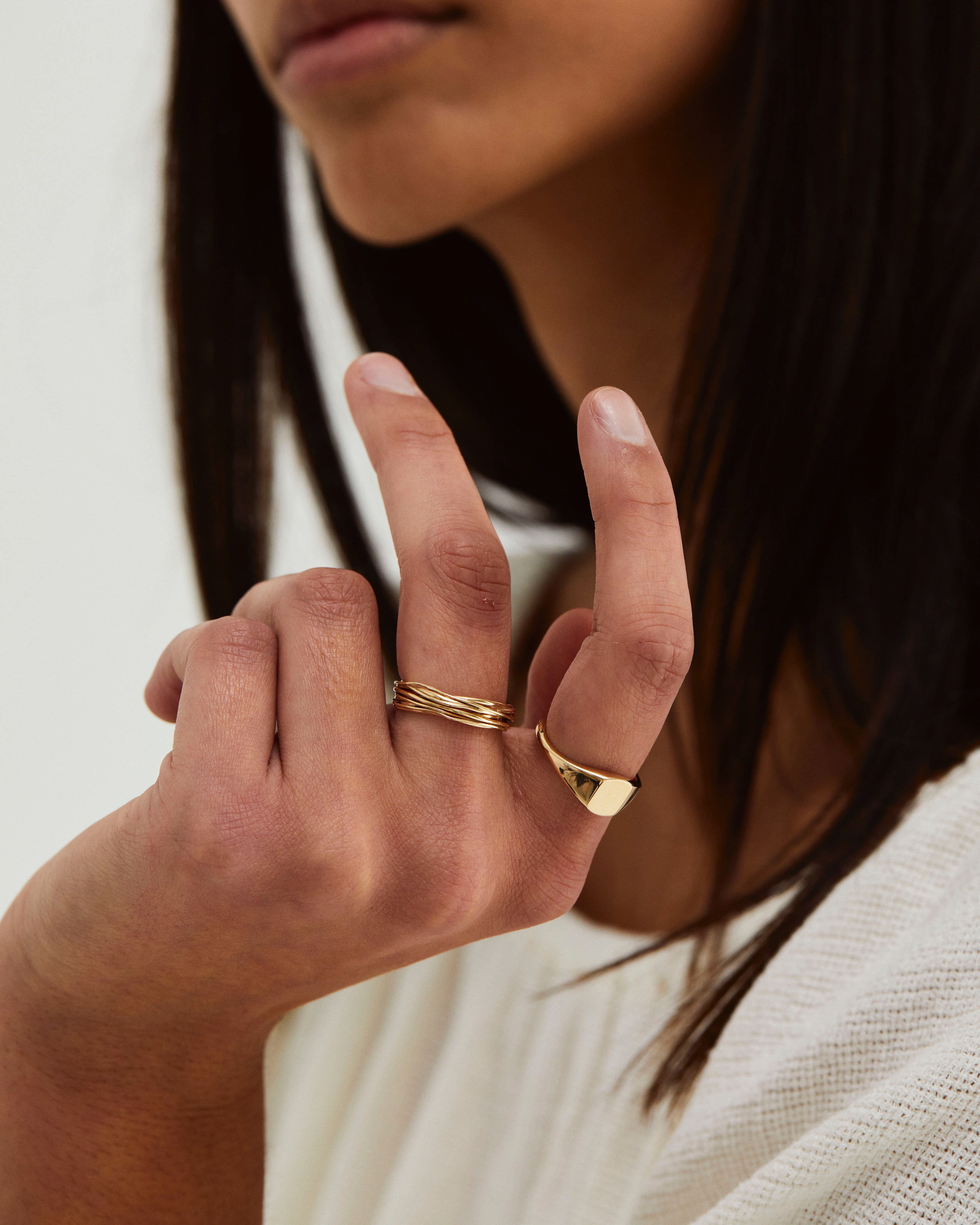 A woman wearing the Kamali Ring and Fei Signet, both in yellow gold.