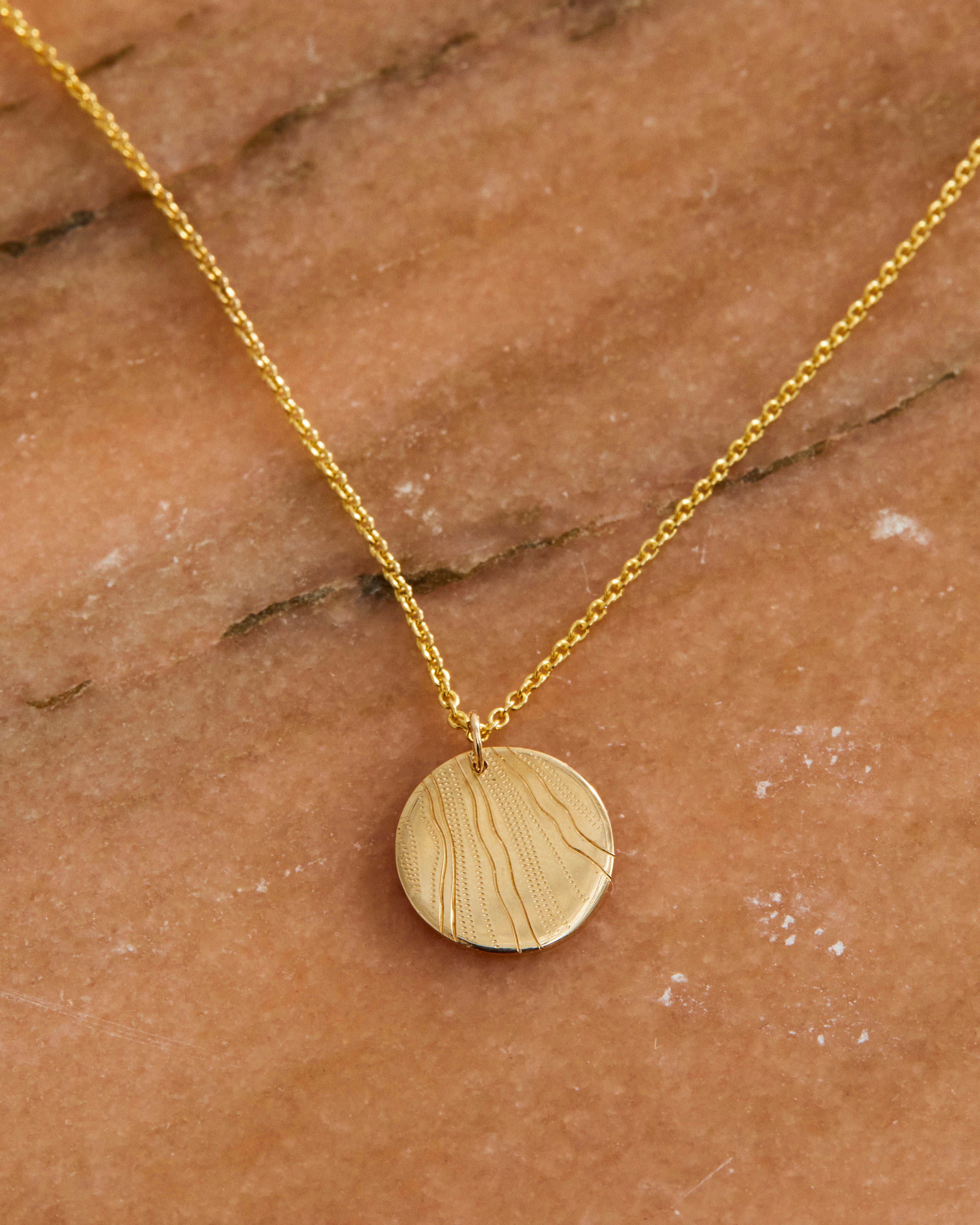 A close up on the Nhurali Necklace in yellow gold.