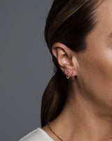 A close up an on an earring stack featuring a Cara Stud and the Dà anam Hoops.