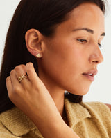 A model wears the balance ring stacked with square wedding ring and dotted stacking ring in yellow gold