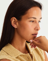 A woman wearing the Moon Studs and Tiny Dot Studs, both in yellow gold.