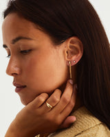 Woman wearing a diamond round stud and a diamond cluster chain earring
