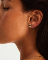 A woman wearing the Dotted Mana Studs and the Tellue Drop Studs, both in yellow gold.