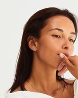 A model wears a ear stack of our Pear Diamond Cluster Studs and Vega Studs in Sapphire