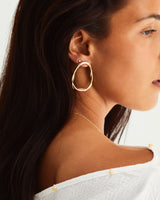 A woman wearing the Dalí Earrings in yellow gold.