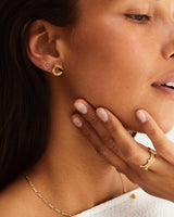 A woman wearing the Agate Studs in yellow gold.