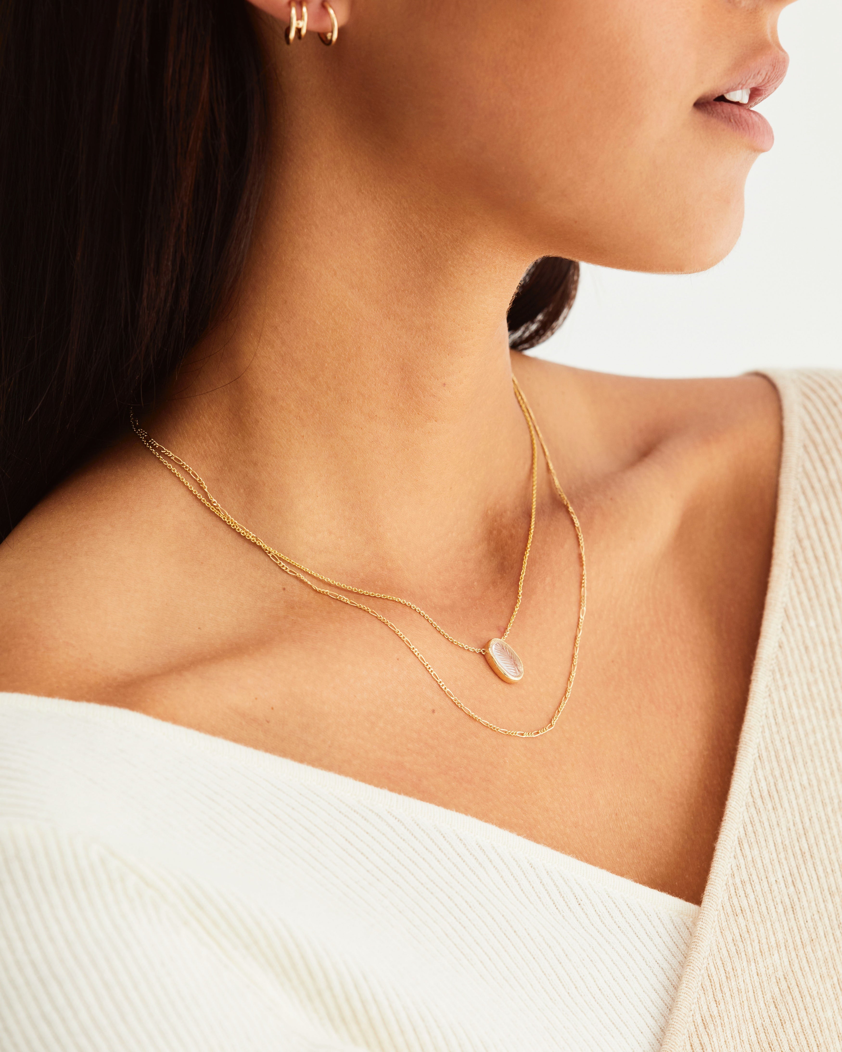 A woman wearing the Ruan Necklace | Carved Quartz in yellow gold.