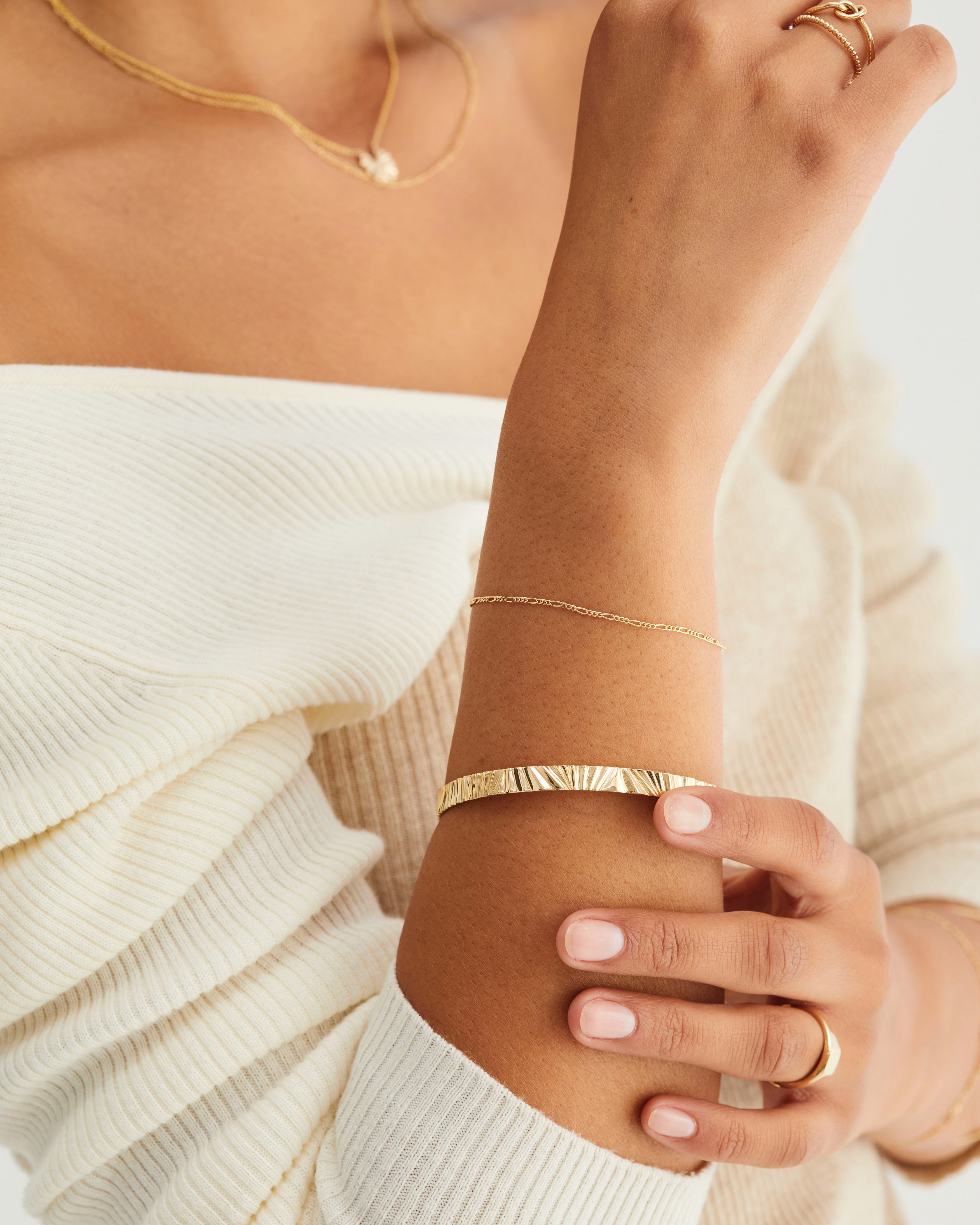 A woman wearing the Pan Bangle in yellow gold.