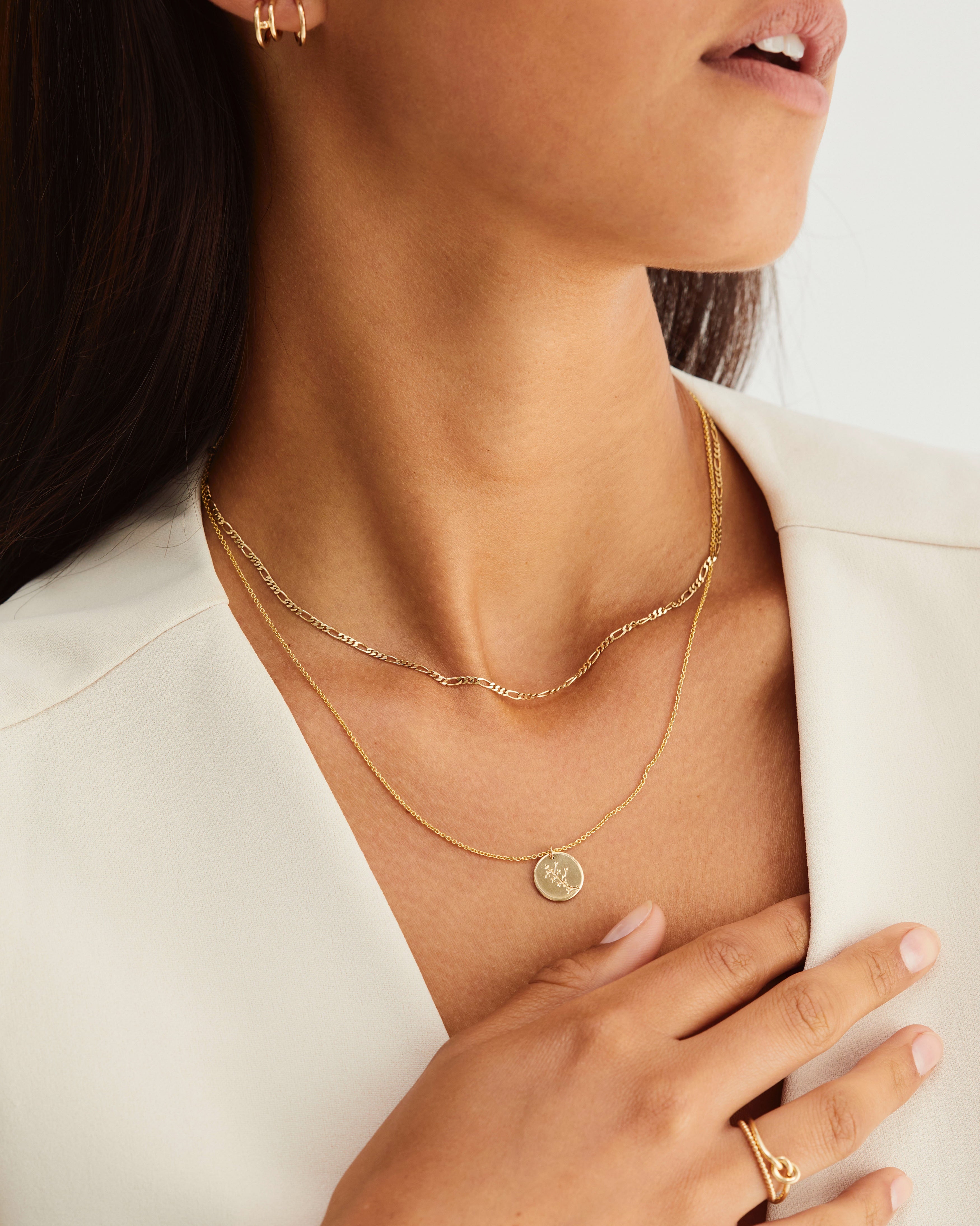 A woman wearing the Clematis Vine Necklace in yellow gold.