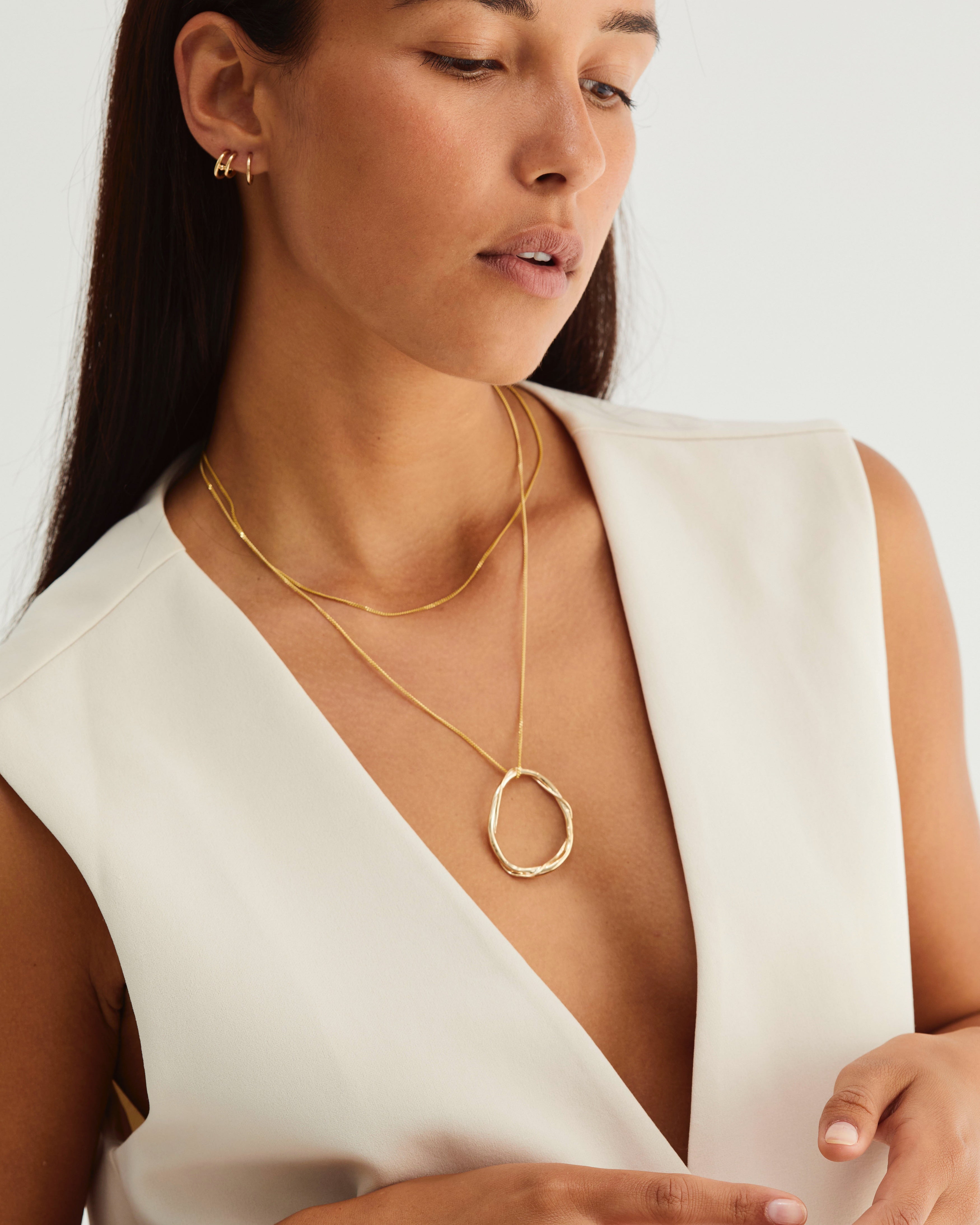 A woman wearing the Dalí Necklace in yellow gold.