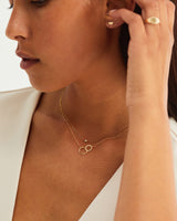 A woman wearing the Cascade Loop Through Oval Necklace | Diamonds in yellow gold.