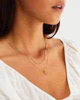 A woman wearing the Una Necklace | Rutaliated Quartz in yellow gold.