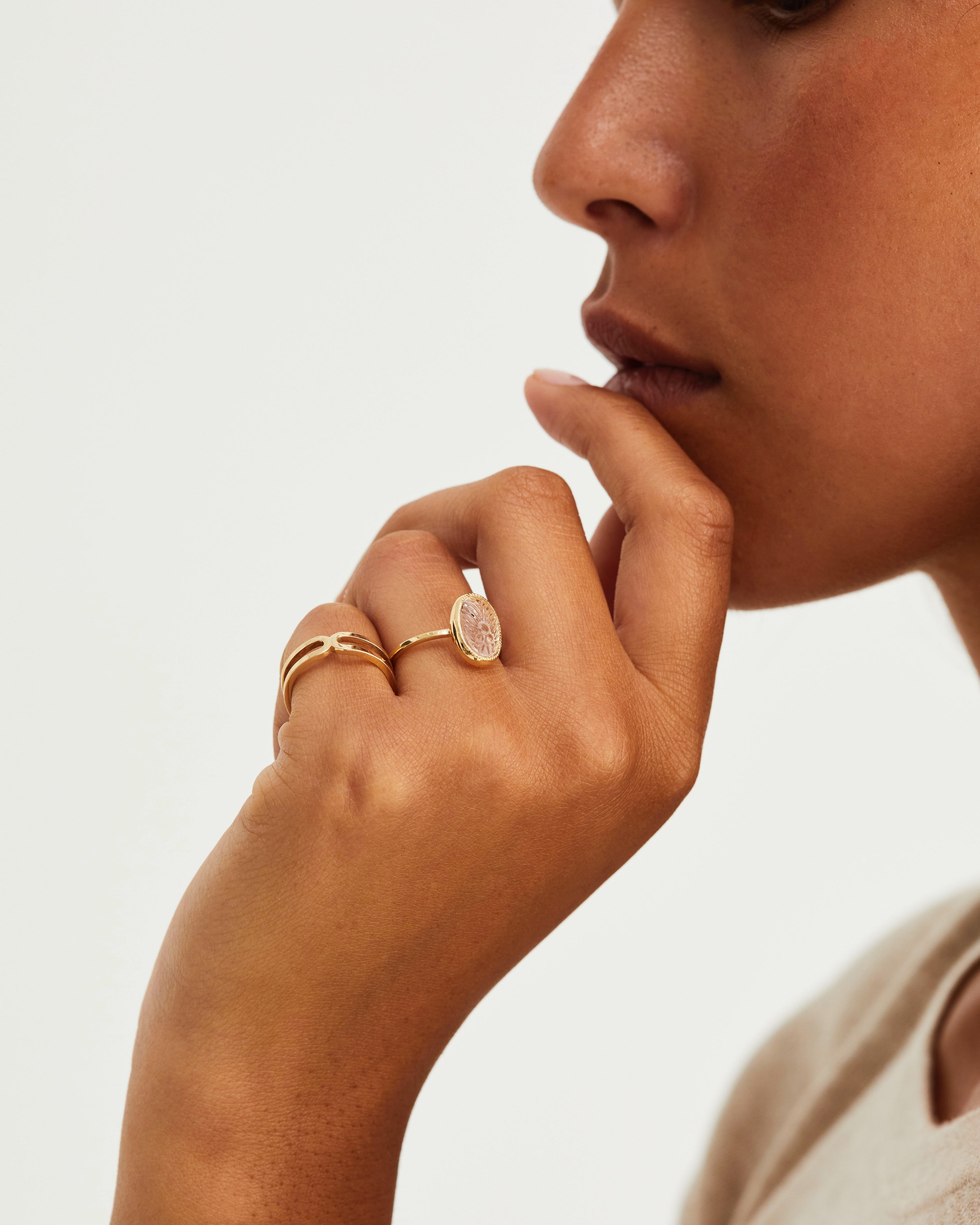 A woman wears the Ailing Cuff Ring on her pinky, and Ruan Carved Stone Ring in yellow gold