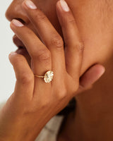 A hand adorned with the Pan Ring in yellow gold.