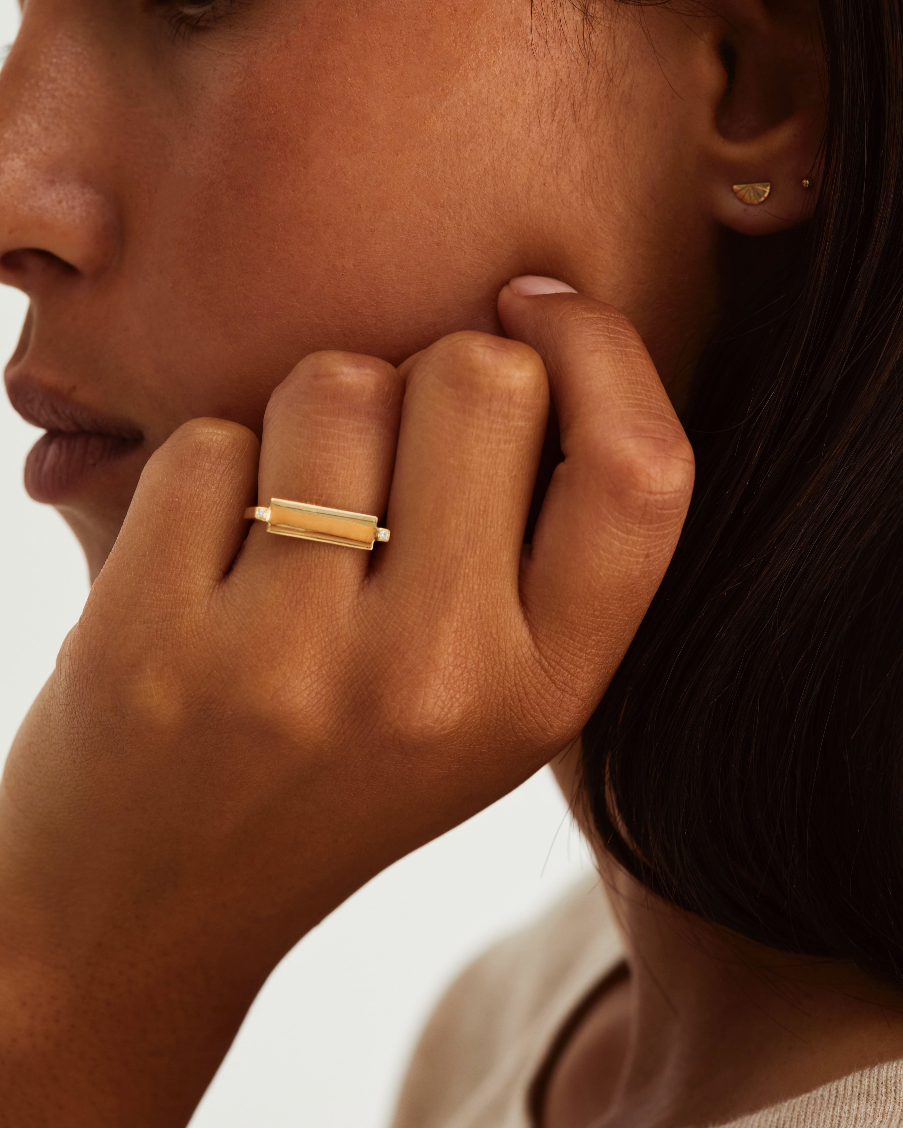 A woman wears the Antares Plate Ring in yellow gold