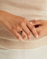 A woman wearing the Fei Ring | Black Spinel and Tiny Fei Ring | Black Spinel, both in yellow gold.