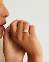 A woman wears the double cascade diamond band stacked with the diamond mandala solitaire, in yellow gold