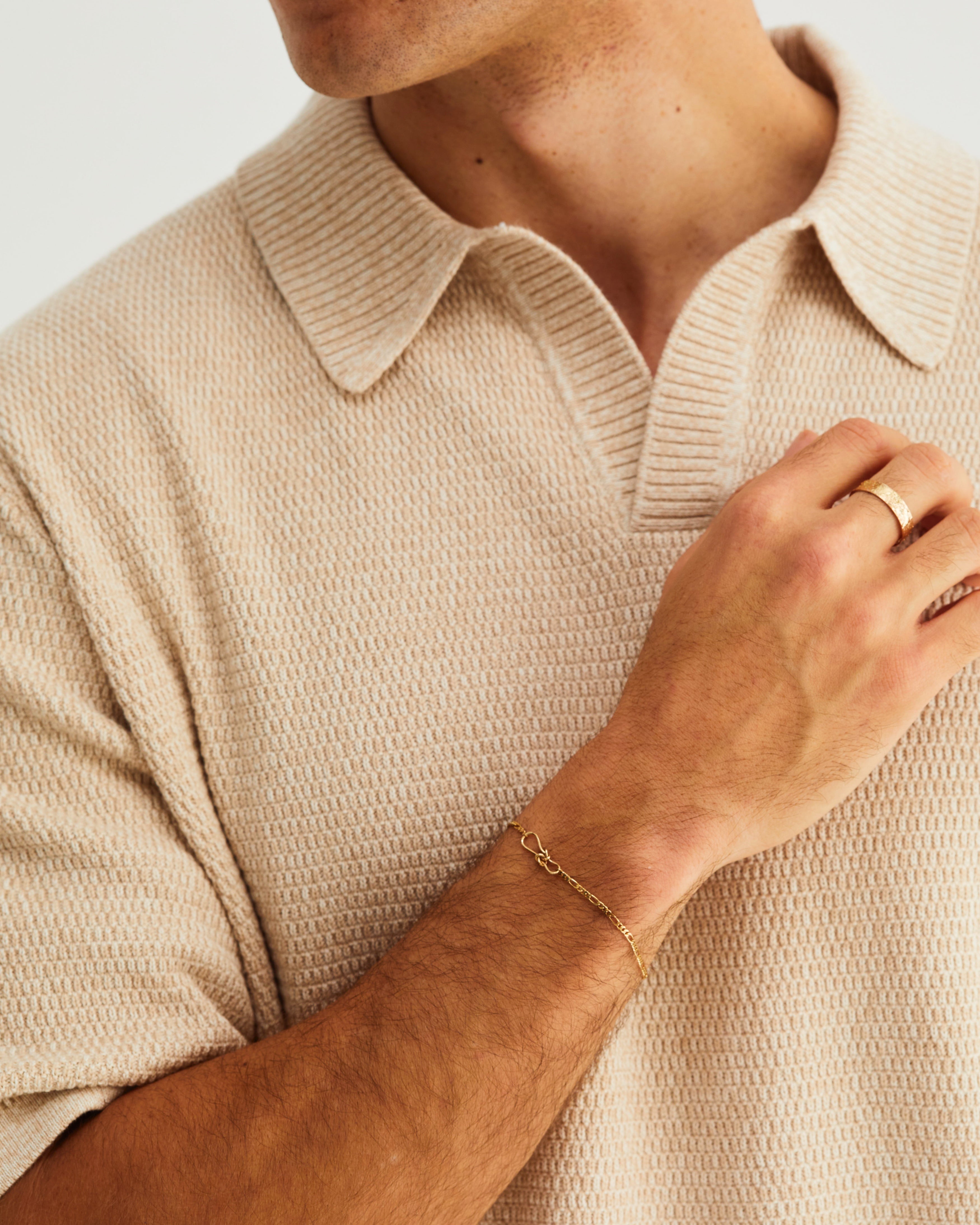 A man wears the Anam Bracelet in yellow gold