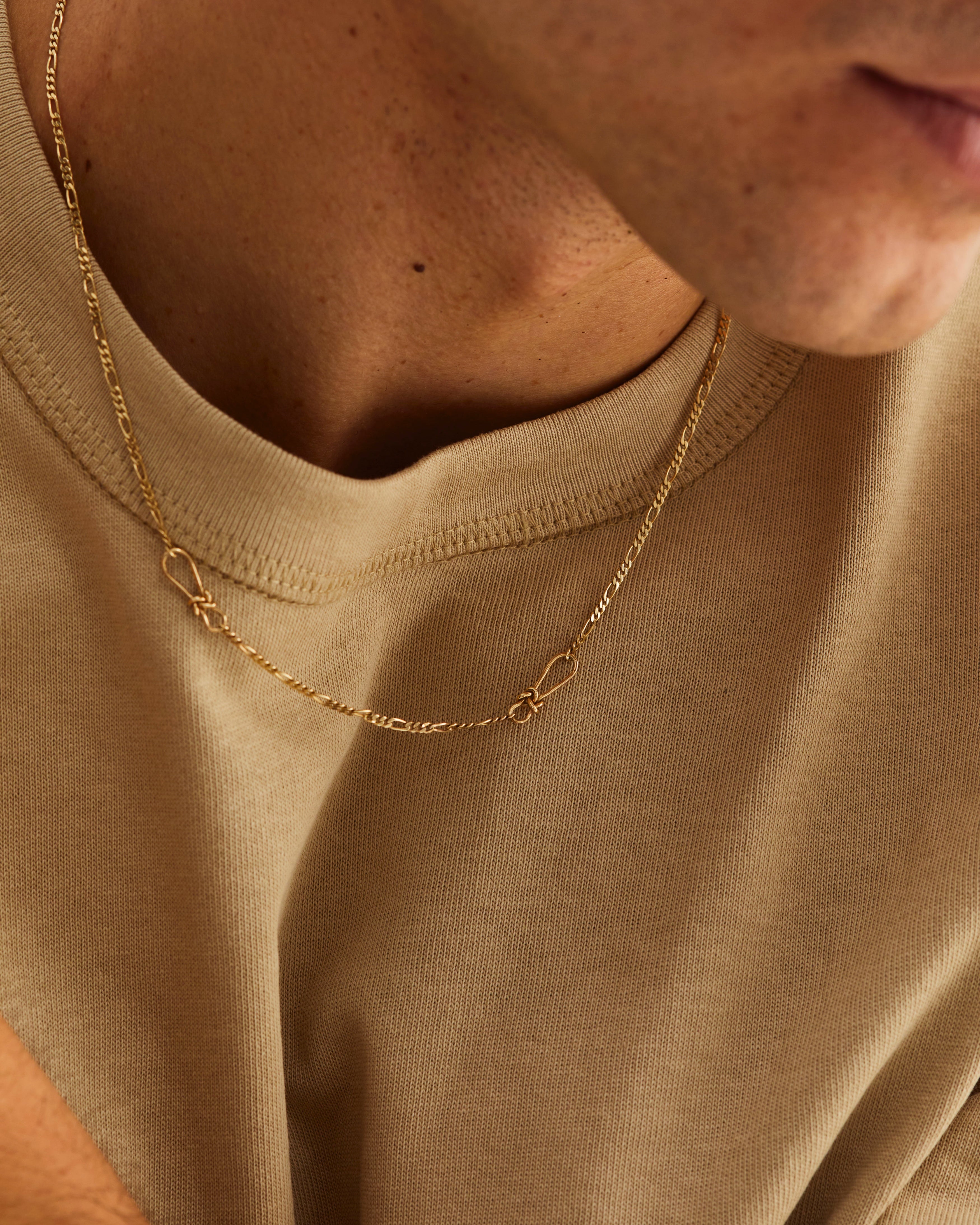 A man wears the Da Anam Necklace in Yellow Gold