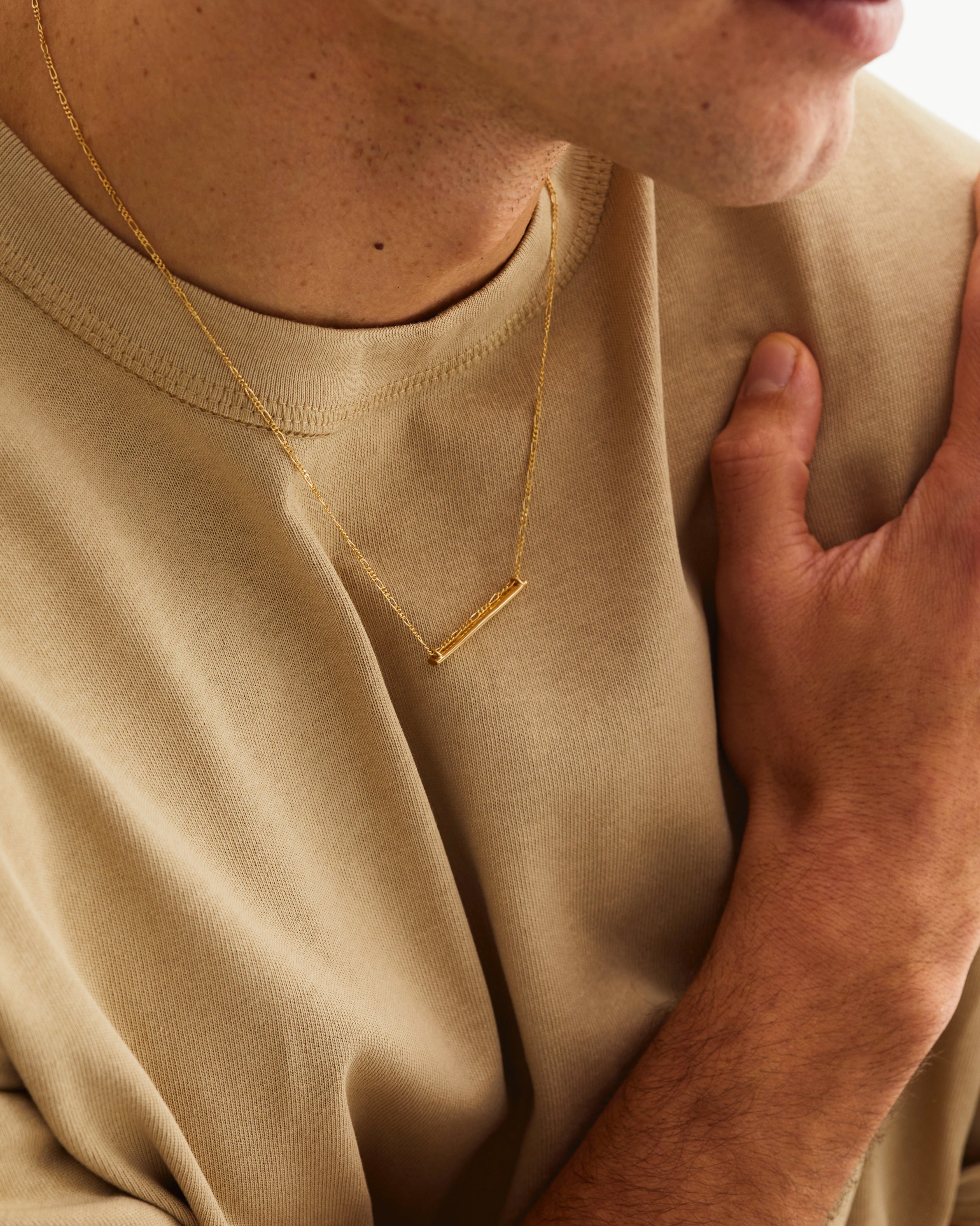 A man wears the Ellipse Necklace in yellow gold