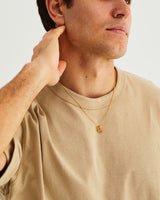 A man wears the Six Oval Necklace in yellow gold