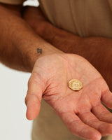 A man holding the Aeneid Wedding Coin in his palm