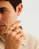 A man wears the Arden Signet ring with the Dali Ring, in yellow gold