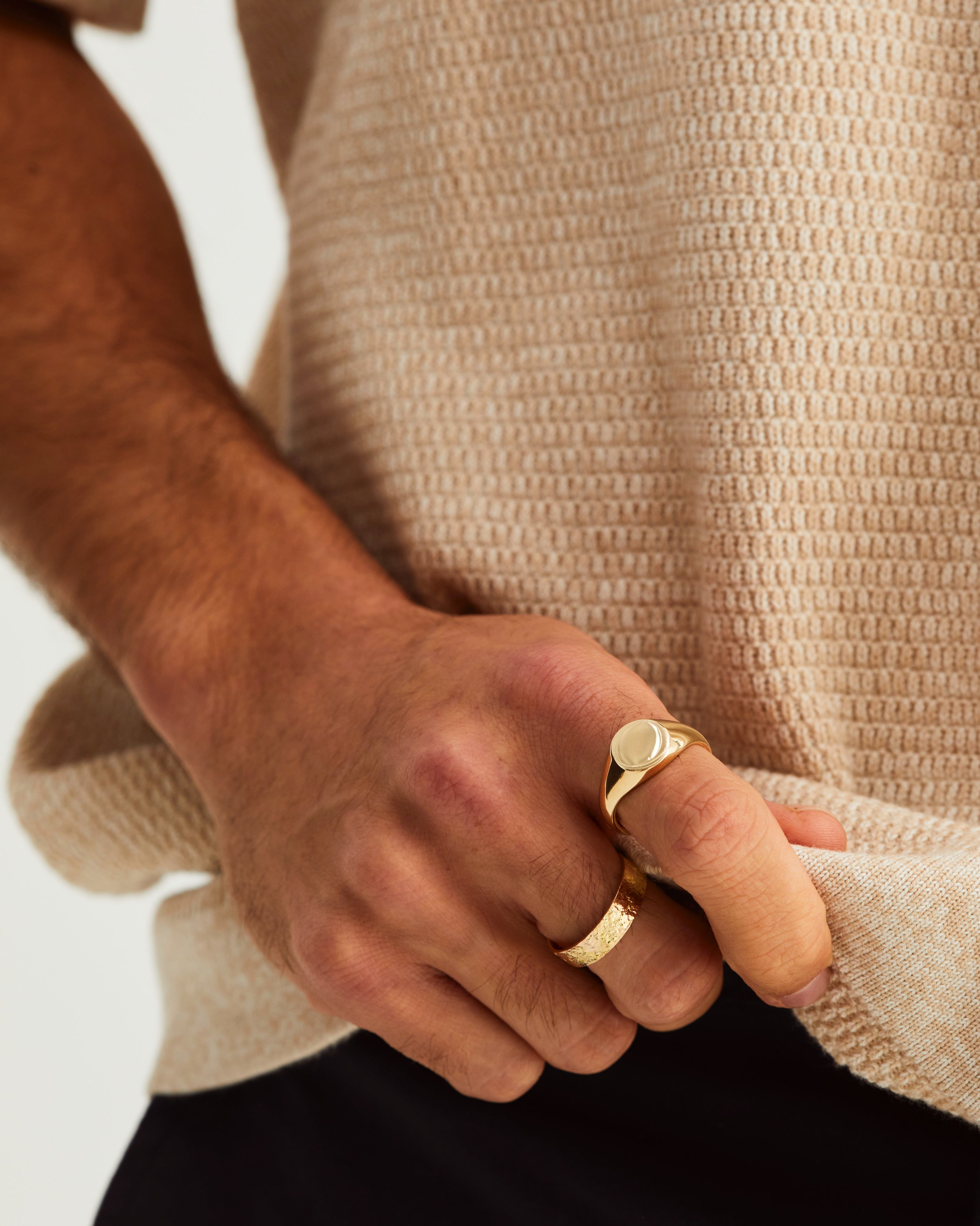 A man wears a Kian Signet and the Naum Heavy Stacking Ring in Yellow Gold