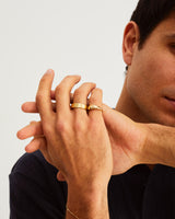A man wears the Seule Ring and bold wedding band in yellow gold