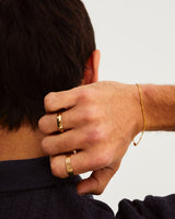 A man wears the knife edge wedding ring in 4mm and heavy naum ring in yellow gold
