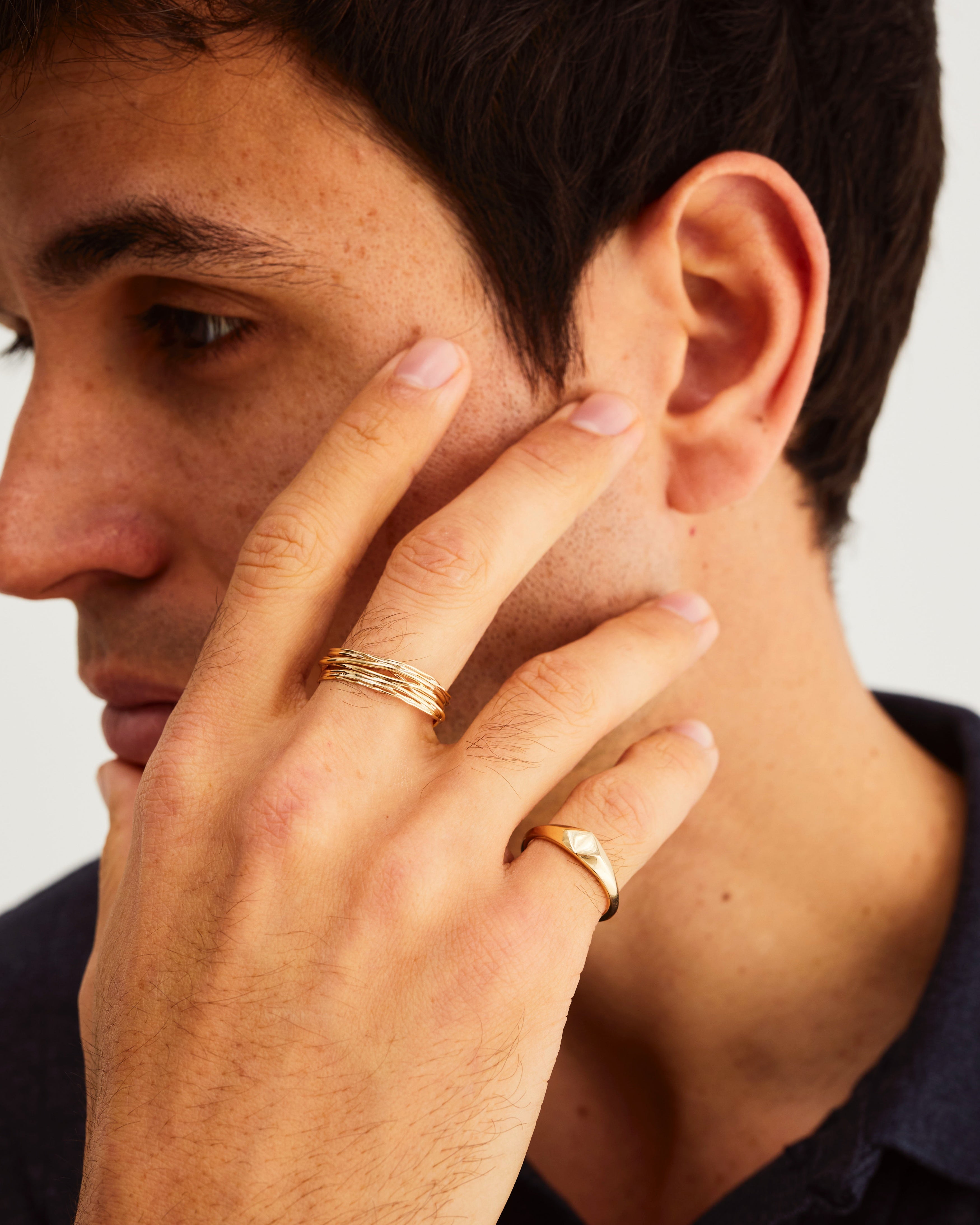 A man wears the Nuna Signet and Kamali Ring in Yellow Gold