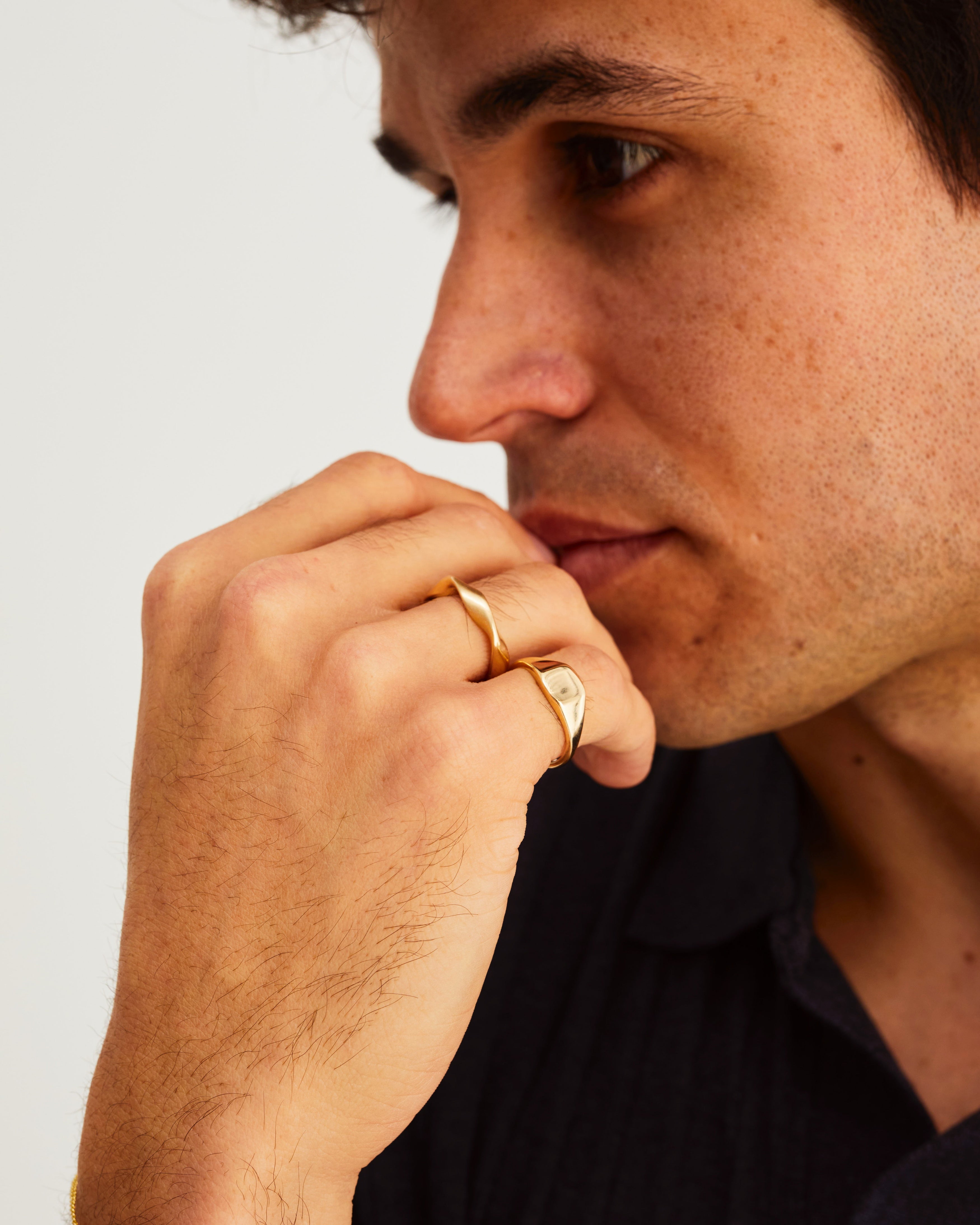 A man wears the Fei Signet with Ellipse Shift Ring in Yellow Gold