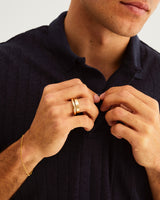 A man wears a 4mm bold curve ring stacked with a flat wedding band in yellow gold