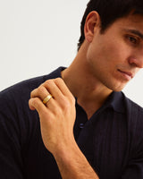A man wears 4mm chamfered wedding ring in yellow gold