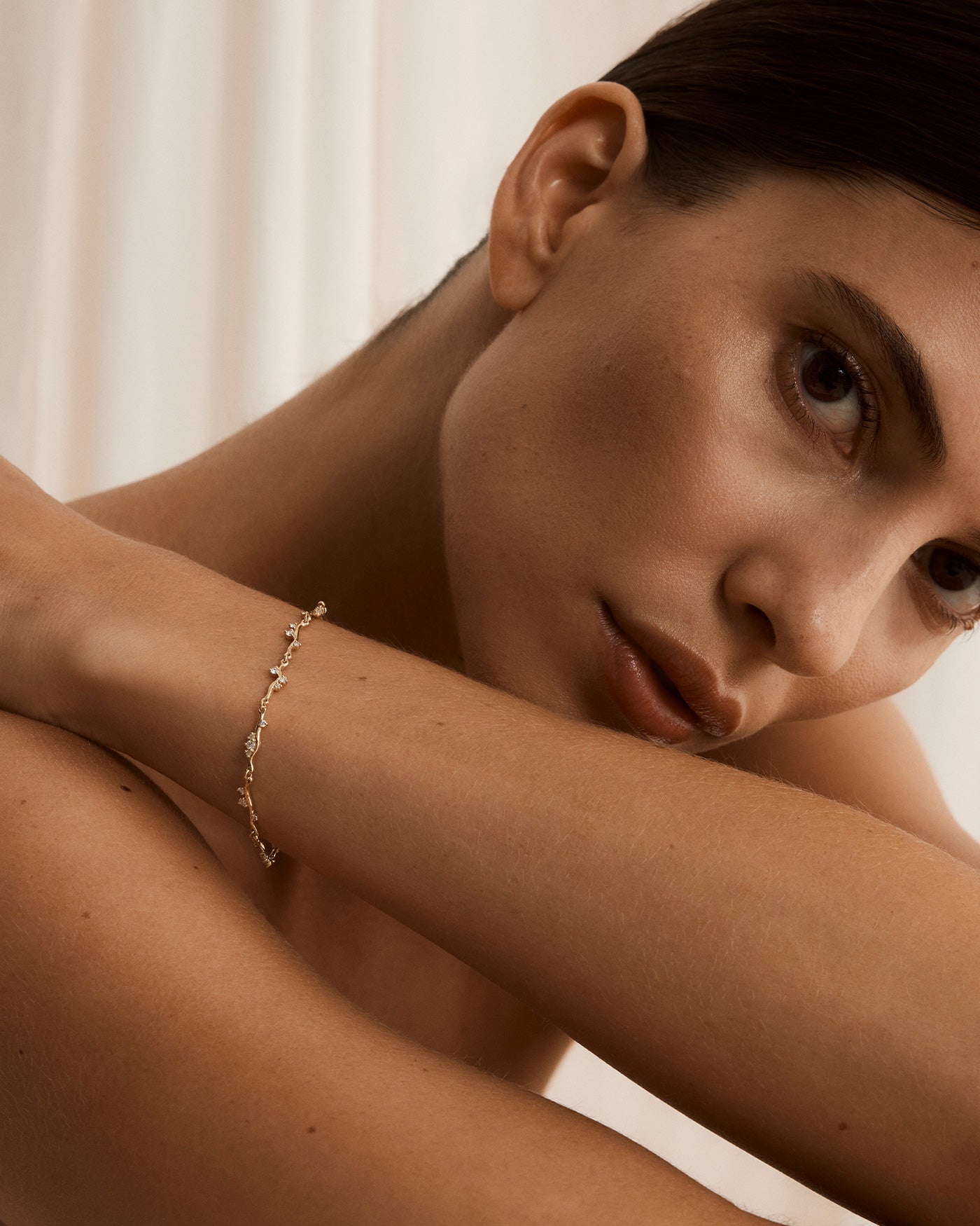Model wearing ember bracelet with diamonds in yellow gold