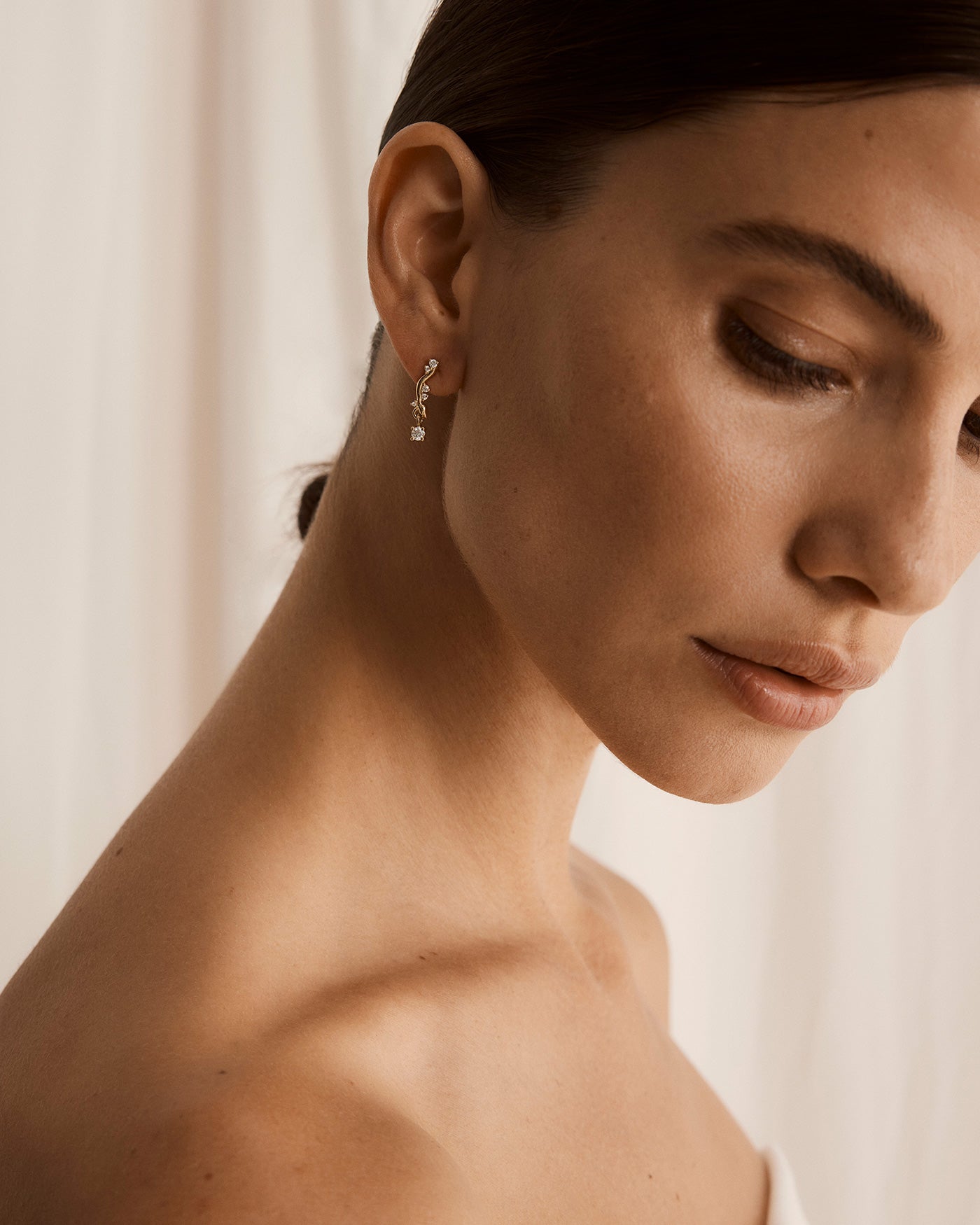 Photo of model wearing yellow gold diamond drop earrings